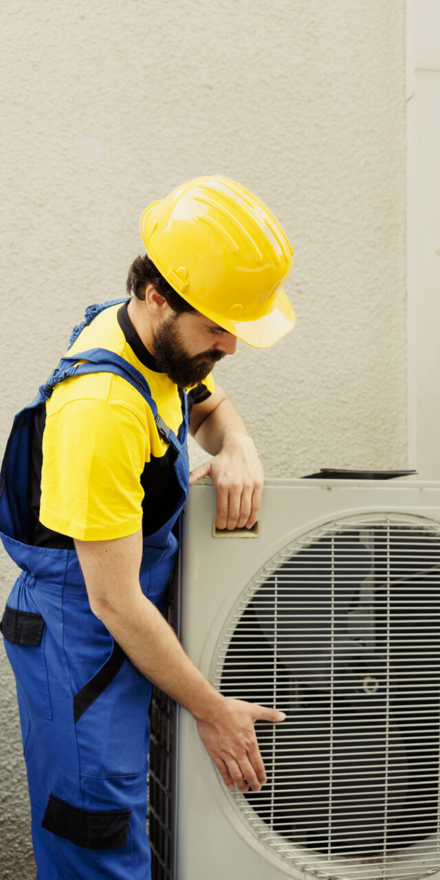 Certified technician getting new outdoor air conditioner ready after replacing old busted unit. Trained engineer contracted to install new condenser and make sure it operates at maximum power